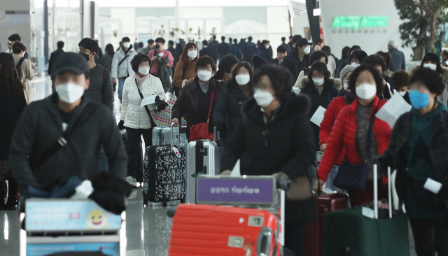 신종 코로나바이러스 감염증 확산이 우려되고 있는 2일 오후 인천공항 2터미널에서 이용객들이 마스크를 착용하고 이동하고 있다. 연합뉴스