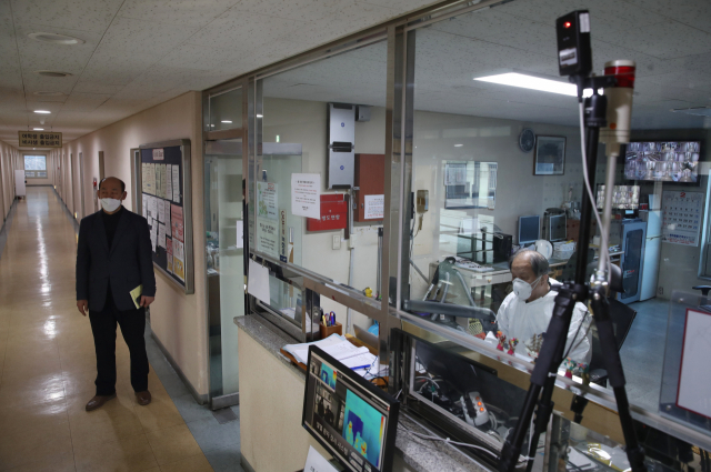 13일 오후 서울 동대문구 경희대학교의 외국인 기숙사인 세화원에 열화상 카메라가 설치된 가운데 방역복을 입은 관계자가 근무를 서고 있다. 연합뉴스