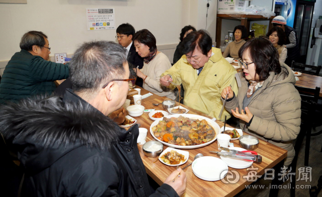 안동시가 코로나19 여파로 침체된 지역경기 활성화와 시민 불안감을 잠재우기 위해 17일부터 공무원들이 전통시장 이용하기를 일상화하기로 했다. 사진은 권영세 안동시장 등 공무원들이 점심시간에 구시장 찜닭골목에서 점심을 먹는 모습. 안동시 제공
