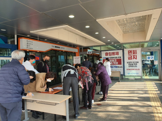 20일 대구 동구 파티마병원 본관 입구에서 내원객들이 문진표를 작성하고 있다. 김태진 기자