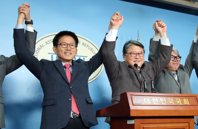 20일 국회 정론관에서 열린 우리공화당-자유통일당 통합추진 발표 기자회견에서 우리공화당 조원진 대표와 자유통일당 김문수 대표가 손을 맞잡고 있다. 연합뉴스