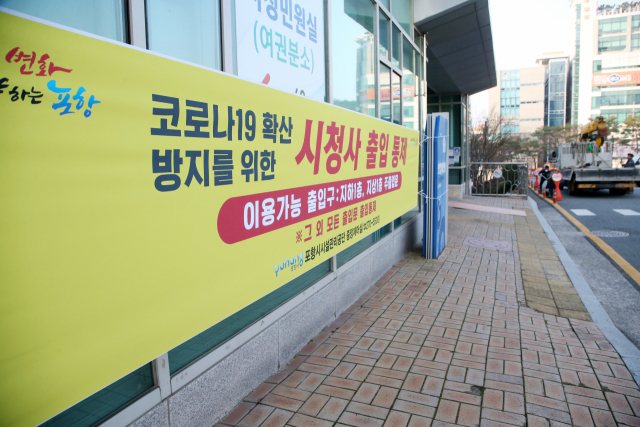 신종 코로나바이러스 감염증(코로나19) 확산에 따라 경북 포항시청에 출입문을 일원화한다는 안내문이 걸려 있다. 시는 출입문에 열감지카메라를 설치하고 손소독제를 비치해 의무적으로 손을 닦도록 하고 있다. 연합뉴스