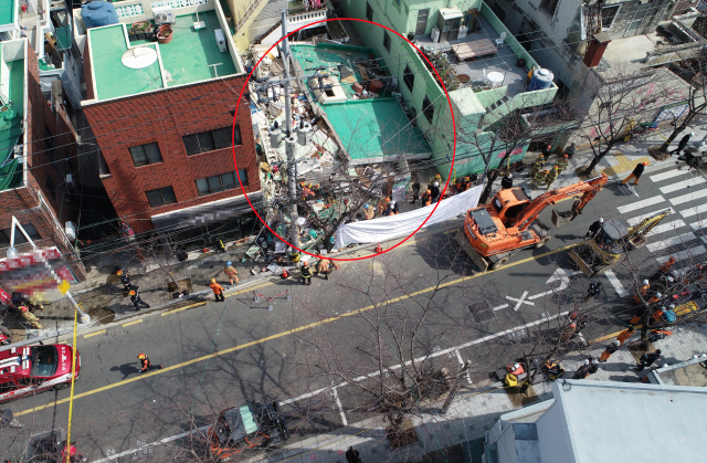 21일 오전 11시 4분께 부산 연제구 한 단독주택 철거 작업 현장에서 건물이 붕괴해 소방대원들이 매몰자를 구조하고 있다. 연합뉴스