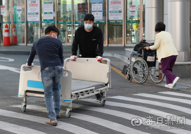 21일 대구시가 대구의료원 모든 병동을 코로나19 환자를 입원 치료하는데 사용키로 함에 따라 대구의료원 직원들이 병상 침대를 병동에서 꺼내 옮기고 있다. 대구시는 이날부터 코로나19 환자 입원치료 대응지침을 일반병실(1인 다실) 체계로 전환했다. 우태욱 기자 woo@imaeil.com