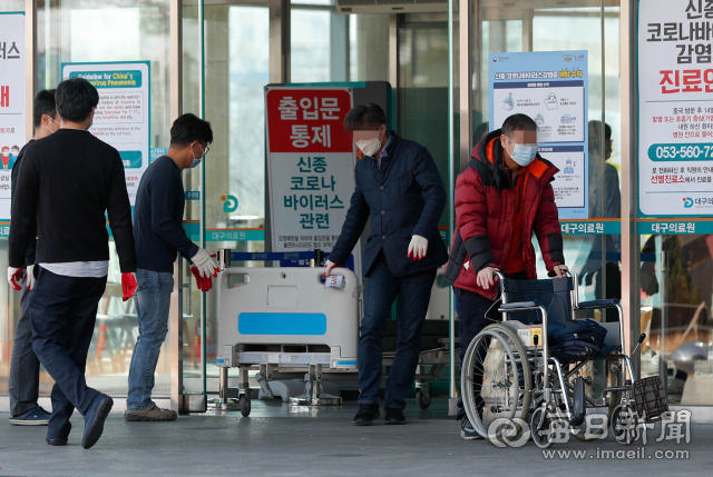 21일 대구시가 대구의료원 모든 병동을 코로나19 환자를 입원 치료하는데 사용키로 함에 따라 대구의료원 직원들이 병상 침대를 병동에서 꺼내 옮기고 있다. 대구시는 이날부터 코로나19 환자 입원치료 대응지침을 일반병실(1인 다실) 체계로 전환했다. 우태욱 기자 woo@imaeil.com