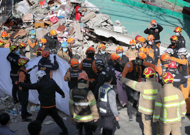 21일 부산 연제구 단독주택 붕괴로 작업자들이 매몰된 현장에서 소방대원들이 5번째 매몰자 구조작업을 펼치고 있다. 이 사고로 총 5명이 매몰됐다가 구조됐으며 이 중 2명은 숨진 것으로 추정된다. 연합뉴스