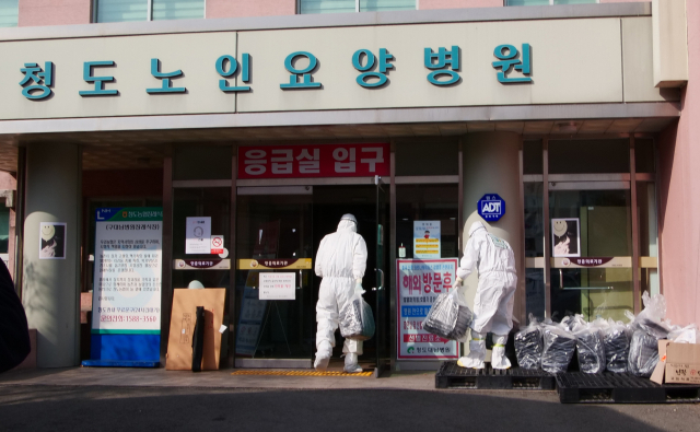 22일 오후 신종 코로나바이러스 감염증(코로나19) 확진자 111명이 입원해 있는 경북 청도군 대남병원에서 방호복을 입은 의료진들이 도시락을 옮기고 있다. 안성완 기자 asw0727@imaeil.com