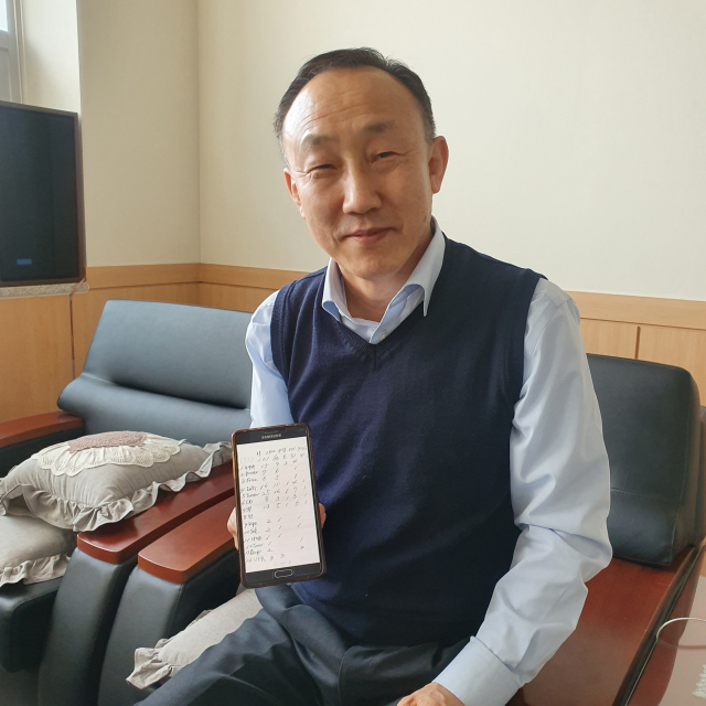 이경훈 관장이 자신이 보유한 오디오 기기 103개를 제품별로 정리해놓은 휴대폰을 들어보이고 있다. 이연정 기자