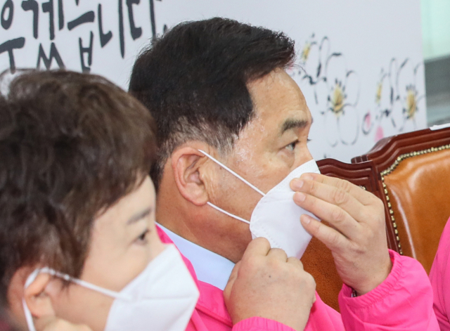 미래통합당 심재철 원내대표가 24일 국회에서 열린 최고위원회의에서 발언을 마친 뒤 마스크를 다시 착용하고 있다. 코로나19 확진을 받은 환자와 접촉한 것으로 알려진 심 원내대표와 일부 의원들은 이날 회의가 끝난 뒤 자진해서 병원 검사를 받았다. 연합뉴스