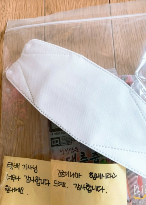 김민정 씨가 택배기사님께 힘내라며 남겨둔 메시지와 마스크. 출처=네이버 카페 