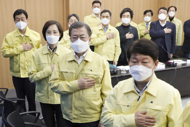 문재인 대통령이 25일 대구시청에서 열린 신종 코로나바이러스 감염증(코로나19) 대구지역 특별대책회의에서 국기에 경례하고 있다. 앞줄 오른쪽부터 권영진 대구시장, 문 대통령, 유은혜 사회부총리, 진영 행안부 장관. 연합뉴스