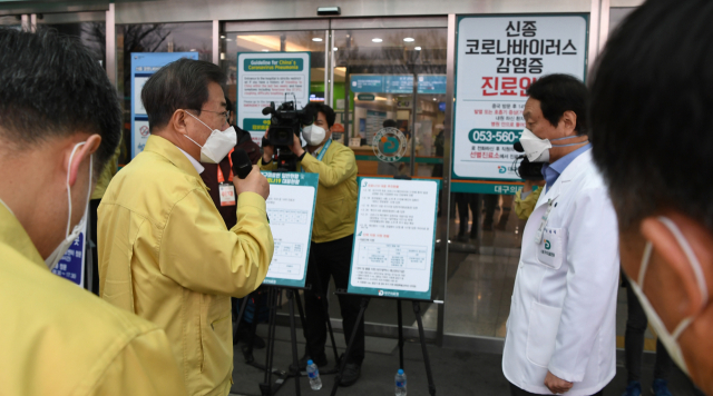 문재인 대통령이 25일 대구의료원에서 유완식 원장의 신종 코로나바이러스 감염증(코로나19) 현황 설명을 듣고 있다. 연합뉴스