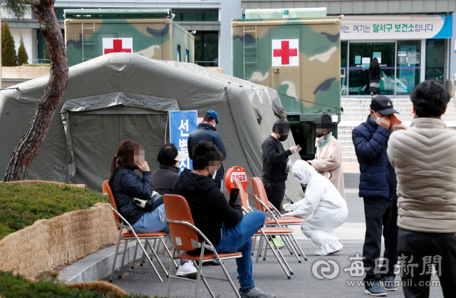 대구지역 코로나19 환자 급증으로 의료 인력과 병상, 장비 부족 사태가 이어지고 있는 가운데 27일 대구 달서구보건소에 군이 지원한 음압텐트가 설치돼 시민들이 진료를 기다리고 있다. 우태욱 기자 woo@imaeil.com