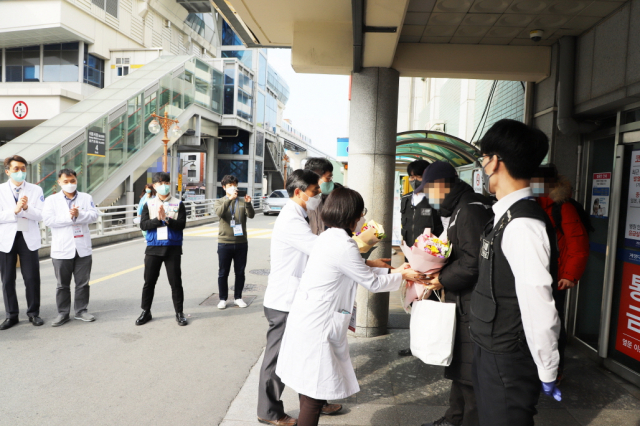계명대 대구동산병원 의료진들이 코로나19 완치자들의 퇴원을 축하하고 있다. 계명대 대구동산병원 제공