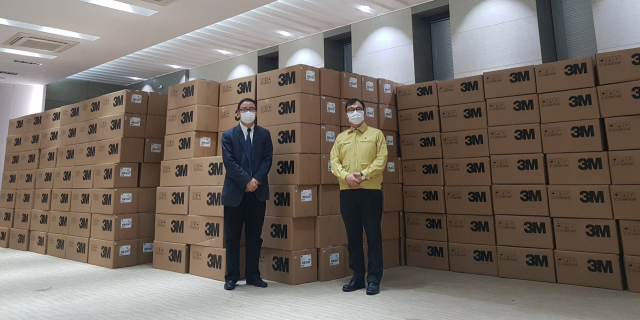 최영삼 주상하이 총영사(오른쪽)가 27일 상하이시 외사판공실 관계자와 함께 기증받은 마스크 앞에 서 기념사진 촬영을 하고 있다. 연합뉴스