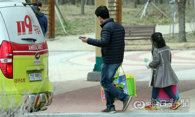 대구 동구 중앙교육연수원에서 격리 치료받던 한 코로나19 환자 가족이 완치돼 퇴원하며 119구급차량으로 향하고 있다. 김태형 선임기자 thk@imaeil.com