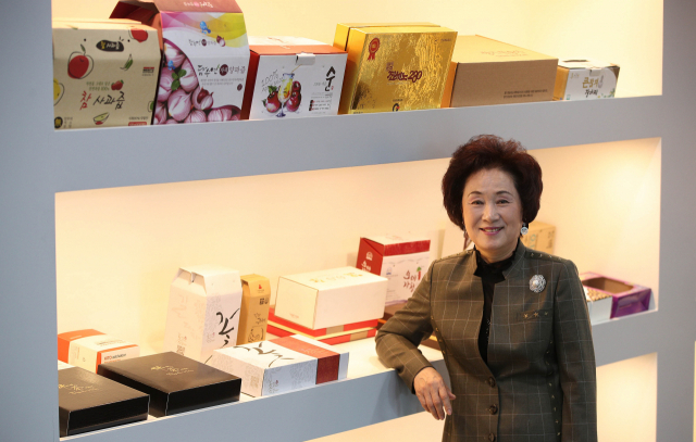 포장디자인 전문기업 ㈜다담 이성월 회장이 자사 종이 포장재 제품 앞에서 포즈를 취하고 있다. 김영진 기자 kyjmaeil@imaeil.com