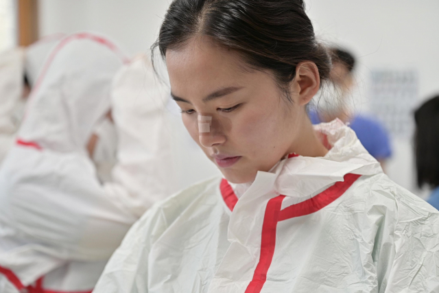 대구동산의료원에서 임무수행 중인 김혜주 대위. 마스크를 오래 써 헐어버린 코 위에 밴드를 붙이고 임무수행 준비를 하고 있다. 국방부 트위터