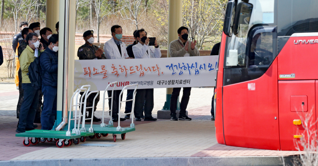 코로나19 경증 확진자가 수용된 대구1생활치료센터에서 첫 퇴원자들이 나왔다. 8일 오후 대구 동구 신서혁신도시 내 중앙교육연수원에 마련한 생활치료센터에서 경증환자 24명이 의료진 및 보건당국 관계자들의 배웅을 받으며 퇴원하고 있다. 지난 2일 입원 후 엿새 만에 센터를 나선 이들은 대부분 당국이 마련한 버스를 타고 인근 지하철 안심역까지 가 지하철 등을 타고 귀가했다. 김영진 기자 kyjmaeil@imaeil.com