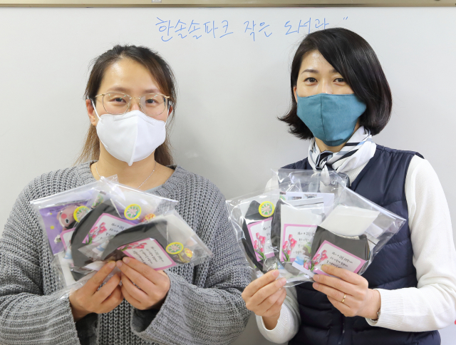 경북 칠곡군 한솔아파트 정혜란(왼쪽) 부녀회장과 석윤정 이장이 직접 만든 면마스크를 들어보이고 있다. 칠곡군 제공