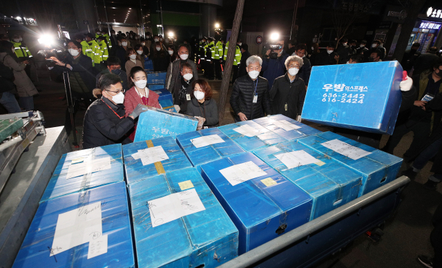 신천지 대구교회 역학조사를 위해 행정조사가 실시된 12일 오후 남구 대명동 신천지 대구교회에서 대구시와 경찰 관계자들이 확보한 서류와 물품 등을 박스에 담아 옮기고 있다. 김영진 기자 kyjmaeil@imaeil.com