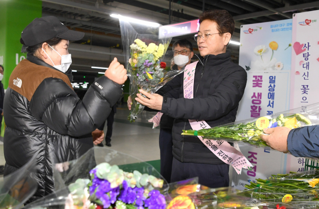 이철우 경북도지사가 13일 화훼농가 위기 극복을 위한 꽃 소비촉진 행사에서 꽃다발을 살펴보고 있다. 경북도 제공