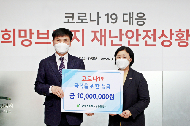 지난 12일 열린 코로나19 극복을 위한 성금 전달식에서 aT 백진석 부사장이 1천만원의 성금을 전국재해구호협회 김정희 사무총장(우측)을 통해 전달하고 있다. aT 제공