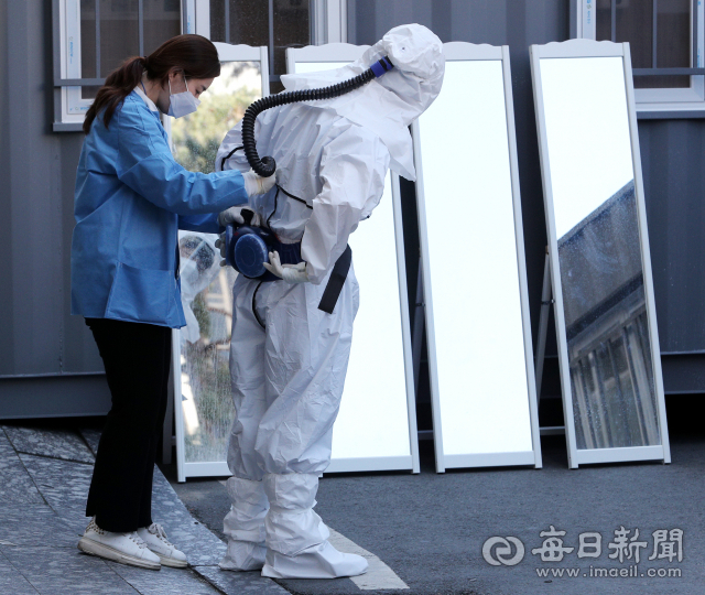 14일 대구 코로나19 지역거점병원인 계명대 대구동산병원에서 한 의료진이 근무 교대를 위해 병원으로 투입되는 의료진의 방호복 착용을 도와주고 있다. 성일권 기자 sungig@imaeil.com