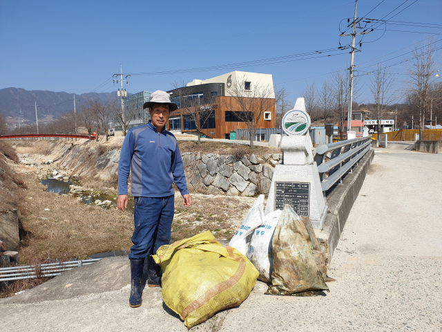 경남 거창읍 동천에서 김광수 씨가 쓰레기를 거둬들이고 있다.이상재