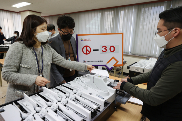 제21대 국회의원 선거를 30일 앞둔 16일 오후 서울 종로구선거관리위원회에서 선관위 직원들이 투표지 분류기를 모의시험하고 있다. 연합뉴스