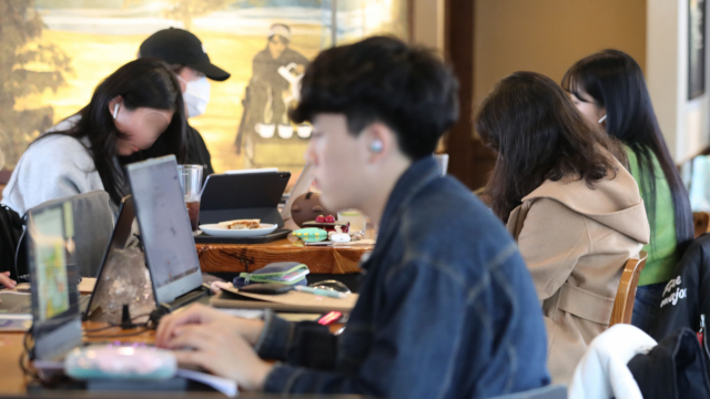 코로나19 확산 예방을 위해 서울 주요 대학이 온라인 강의를 실시한 지 이틀 째인 17일 오후 서울 마포구 홍익대학교 인근 한 카페에서 대학생 및 시민들이 시간을 보내고 있다. 연합뉴스