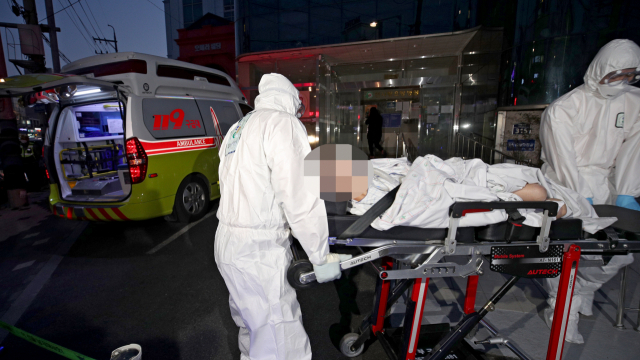 18일 오후 대구 서구 한사랑요양병원에서 코로나 19 확진자가 다수 발생한 가운데 구급대원이 확진자를 병원으로 이송하고 있다. 김영진 기자 kyjmaeil@imaeil.com