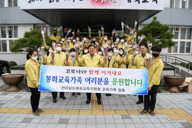 꼿다발 선물을 받아든 봉화교육지원청 직원들이 환한 웃음을 지으며 손을 흔들고 있다. 봉화교육지원청 제공