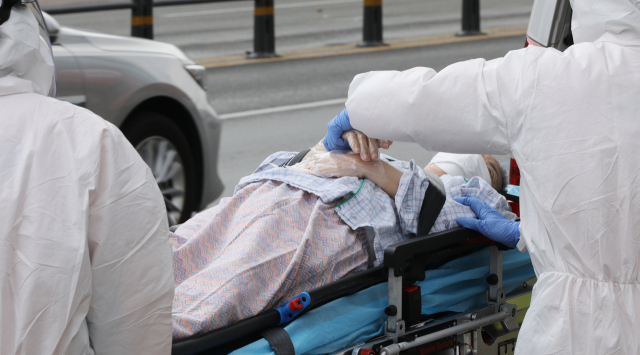 대구 서구 한사랑요양병원에서 구급대원이 코로나19 확진자를 병원으로 이송하고 있는 모습. 김영진 기자 kyjmaeil@imaeil.com