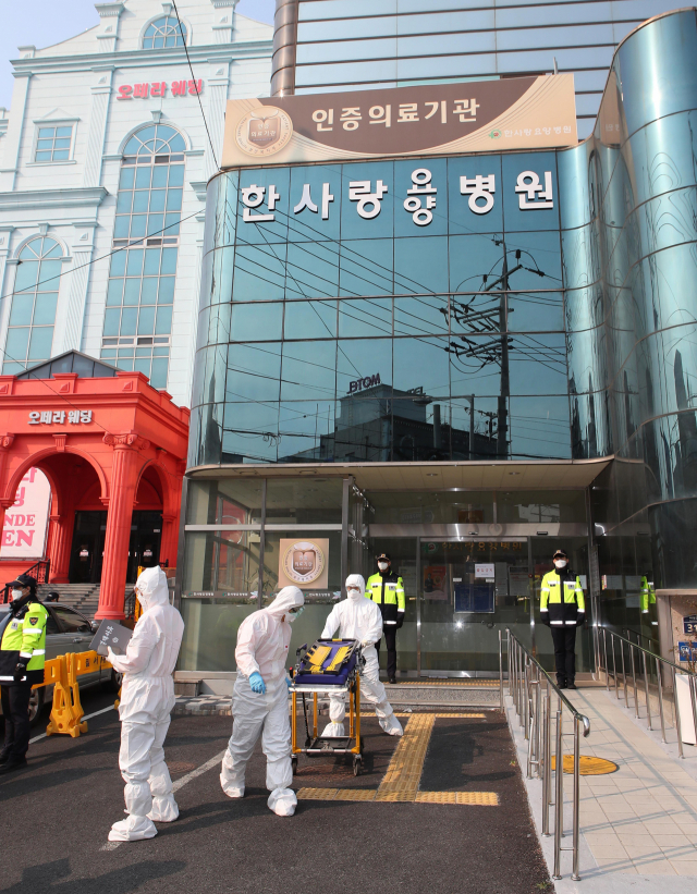 19일 오전 신종 코로나바이러스 감염증(코로나19) 환자가 다수 나온 대구시 서구 한사랑 요양병원에서 119 구급대원들이 코로나19 환자를 대구의료원으로 이송하고 있다. 연합뉴스