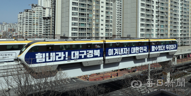 코로나19 사태 극복이 장기전 양상을 보이고 있는 가운데 22일 오후 코로나19를 이겨내자는 캠페인 문구를 래핑한 도시철도 3호선 전동차가 대구 도심을 달리며 시민들을 응원하고 있다. 김태형 선임기자 thk@imaeil.com