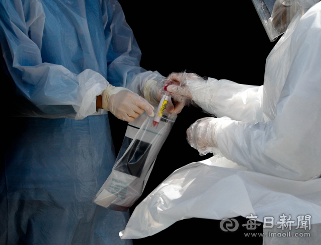 20일 대구 남구 영남대학교병원에서 의료진이 코로나19 의심 환자의 검체를 채취해 밀봉하고 있다. 폐렴 증세로 17세 소년이 사망한 뒤 코로나19 진단검사 중단 조치를 당한 영남대병원은 질병관리본부의 판단에 강하게 반발하고 있다. 우태욱 기자 woo@imaeil.com