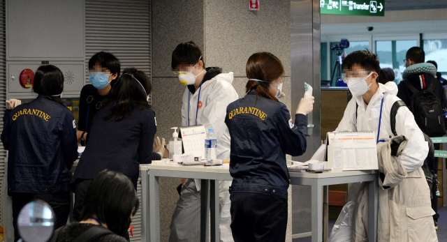 검역당국이 유럽발 모든 여행객들에 대해 코로나19 전수검사를 시행하고 있는 가운데 23일 오전 인천국제공항 1터미널 도착층의 선별진료소에서 런던발 항공기를 이용해 입국한 유증상자들이 검역관과 상담을 하고 있다. 연합뉴스