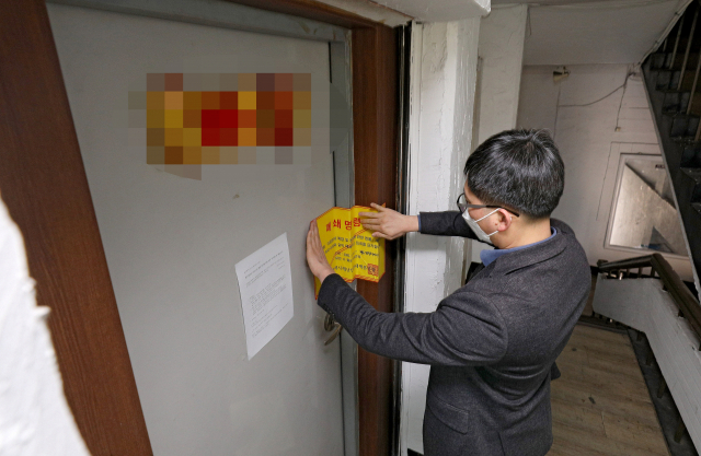 대구 중구의 신천지 교회 부속시설에 대해 대구시 관계자가 폐쇄 명령서를 붙이고 있다. 매일신문DB