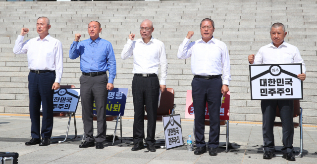 지난해 9월 19일 국회 본청 앞에서 자유한국당 이만희, 김석기, 최교일, 송석준, 장석춘(왼쪽부터) 의원이 조국 법무부 장관의 사퇴를 촉구하며 삭발을 마친 뒤 구호를 외치고 있다. 연합뉴스