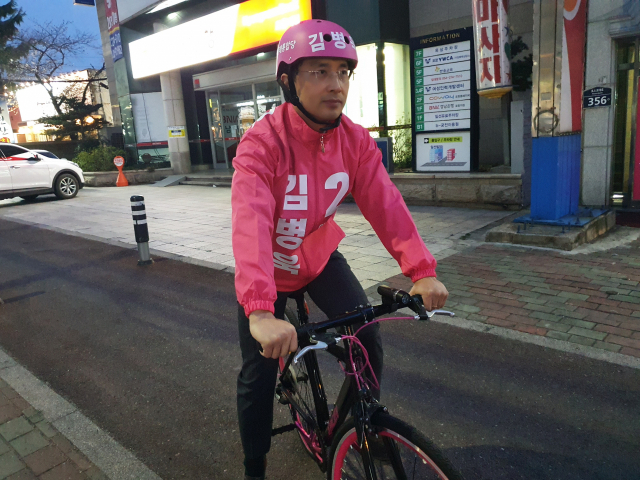 제21대 국회의원 총선거 포항남울릉 선거구에 공천을 받은 김병욱 미래통합당 후보가 25일 오후 자신의 이름이 적힌 분홍색 점퍼와 안전모를 쓴채 자전거를 타고 다니며 이름을 알리는 모습. 분홍색은 통합당을 상징하는 색이다. 김병욱 후보 제공