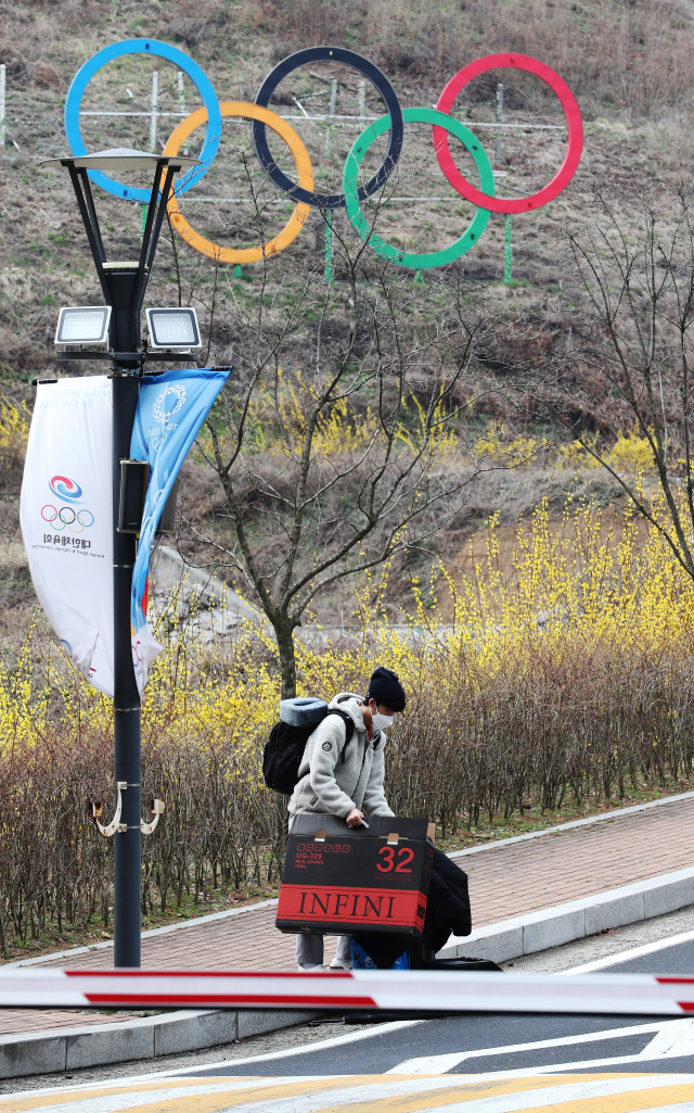 2020 도쿄올림픽 개최 1년 연기와 코로나19 확산으로 진천선수촌이 휴촌에 들어간 27일 충북 진천 국가대표선수촌 웰컴센터 앞에서 사격 이권국 선수가 퇴촌하고 있다. 연합뉴스