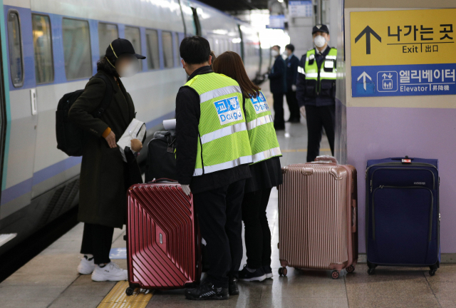 KTX 열차에 탑승한 한 해외입국자가 동대구역에 도착해 대구시 관계자의 안내를 받으며 인적사항을 확인하고 있다. 매일신문DB