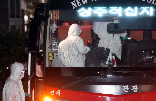 30일 오후 대구시 달성군 다사읍 제2미주병원에서 신종 코로나바이러스 감염증(코로나19) 환자들이 버스를 타고 상주 적십자병원으로 이송되고 있다. 집단 감염이 발생한 대실요양병원과 같은 건물을 사용하는 제2미주병원에서는 코로나19 확진자가 앞서 다수 나왔으며 이날도 추가로 확인됐다. 연합뉴스