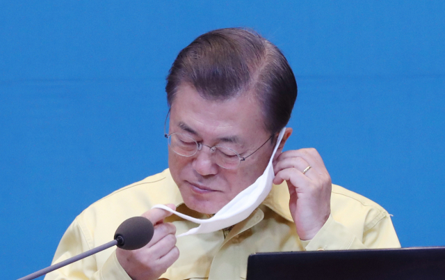 문재인 대통령이 31일 청와대에서 열린 국무회의에서 발언을 위해 마스크를 벗고 있다. 연합뉴스