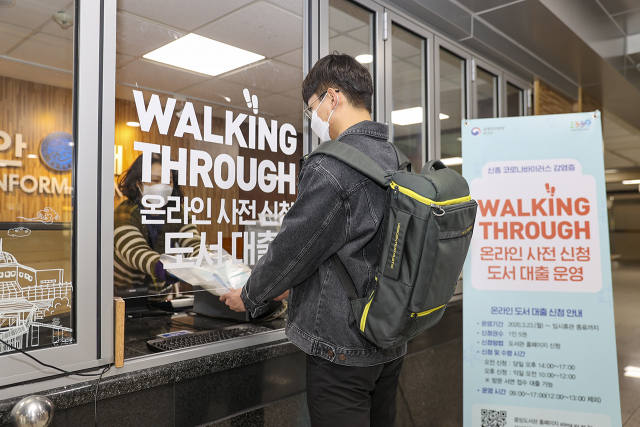 영남대 중앙도서관에서 워킹 스루(Walking Through) 도서 대출 서비스를 이용해 책을 대출하고 있는 학생. 영남대 제공