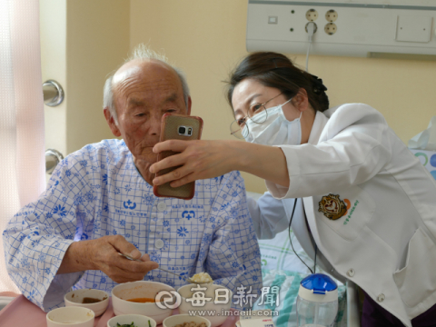 안동유리한방병원 최윤정 간호부장이 가족과 통화하고 싶어하는 환자에게 자신의 휴대전화로 영상통화를 시켜주고 있다. 김영진 기자