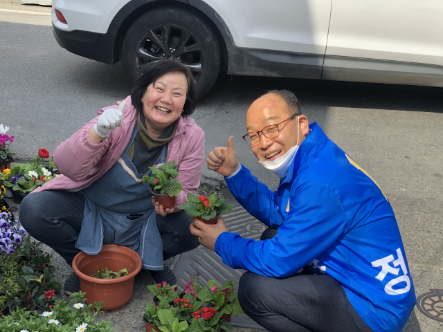 정용운 더불어민주당 후보가 한 상인과 만나 포즈를 취하고 있다.