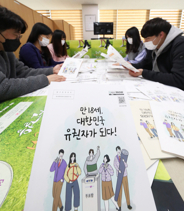 오는 15일 제21대 국회의원선거에서 고3 학생이 생애 첫 투표를 하는 가운데, 지난달 24일 경기도선거관리위원회에서 직원들이 만 18세 유권자를 위한 선거 교육 자료 등을 살펴보고 있다. 연합뉴스