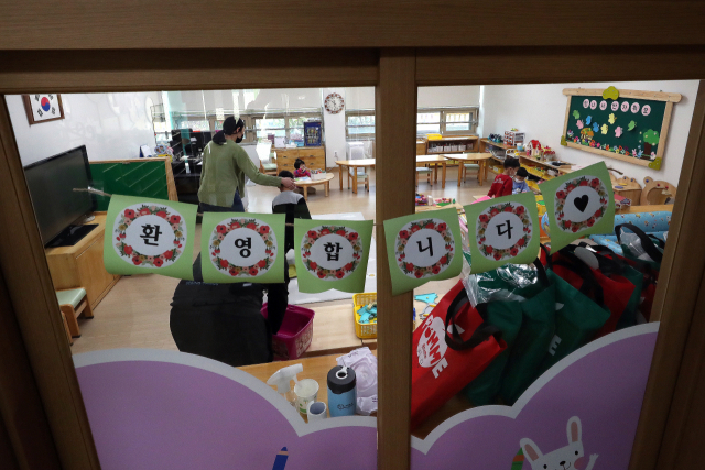 신종 코로나바이러스 감염증(코로나19) 사태가 장기화한 30일 광주 서구 광천초등학교병설유치원에서 긴급돌봄교실 교사가 원아를 맞이하고 있다. 연합뉴스